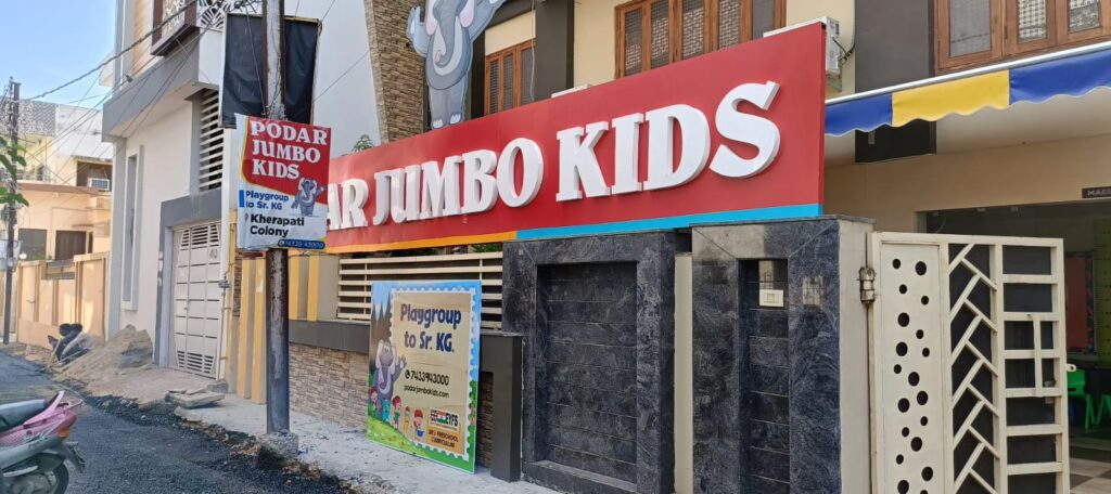 Custom Podar Jumbo Kids signage designed and printed by Dilip Flex Printing, Gwalior, featuring vibrant red and white flex material.